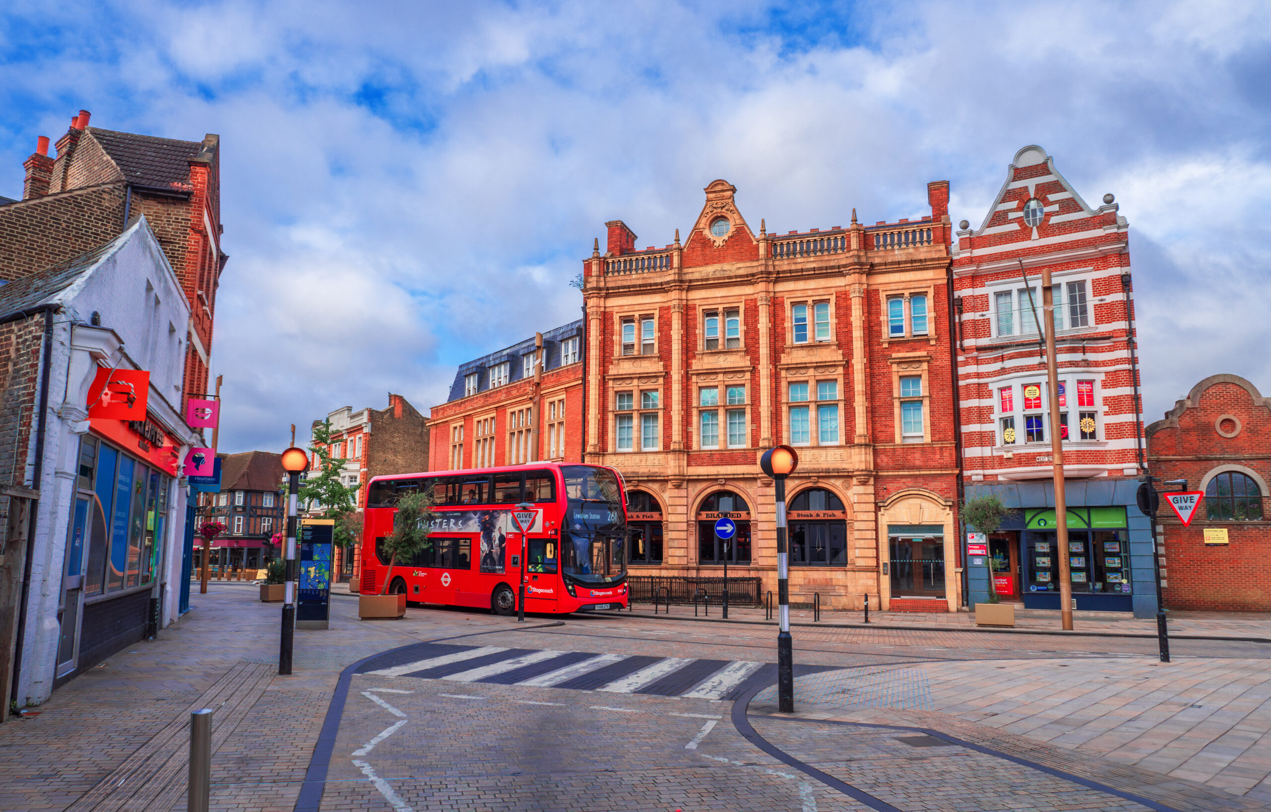 Bromley Borough, London, England – July 21, 2024: Charming Bromley centre: A Picturesque Road with Traditional British Brick Houses,  high street shops and Iconic Double-Decker Bus on East Road