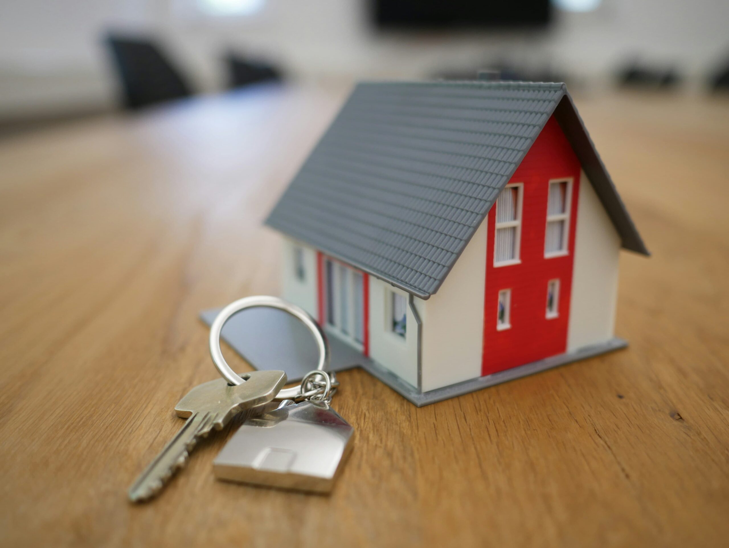 A red and white model of a house next to a pair of keys